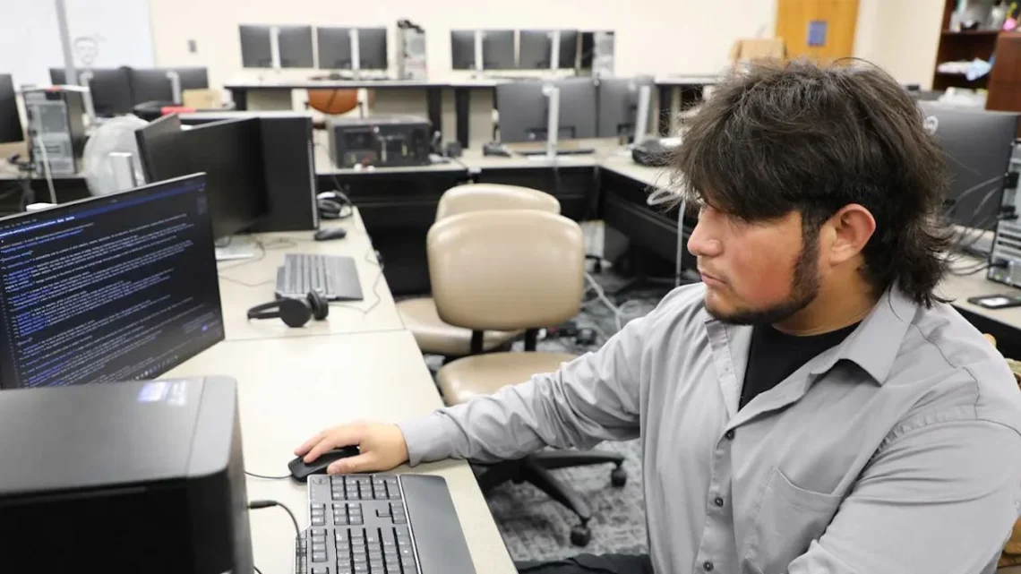 Student working on computer systems in an IT lab