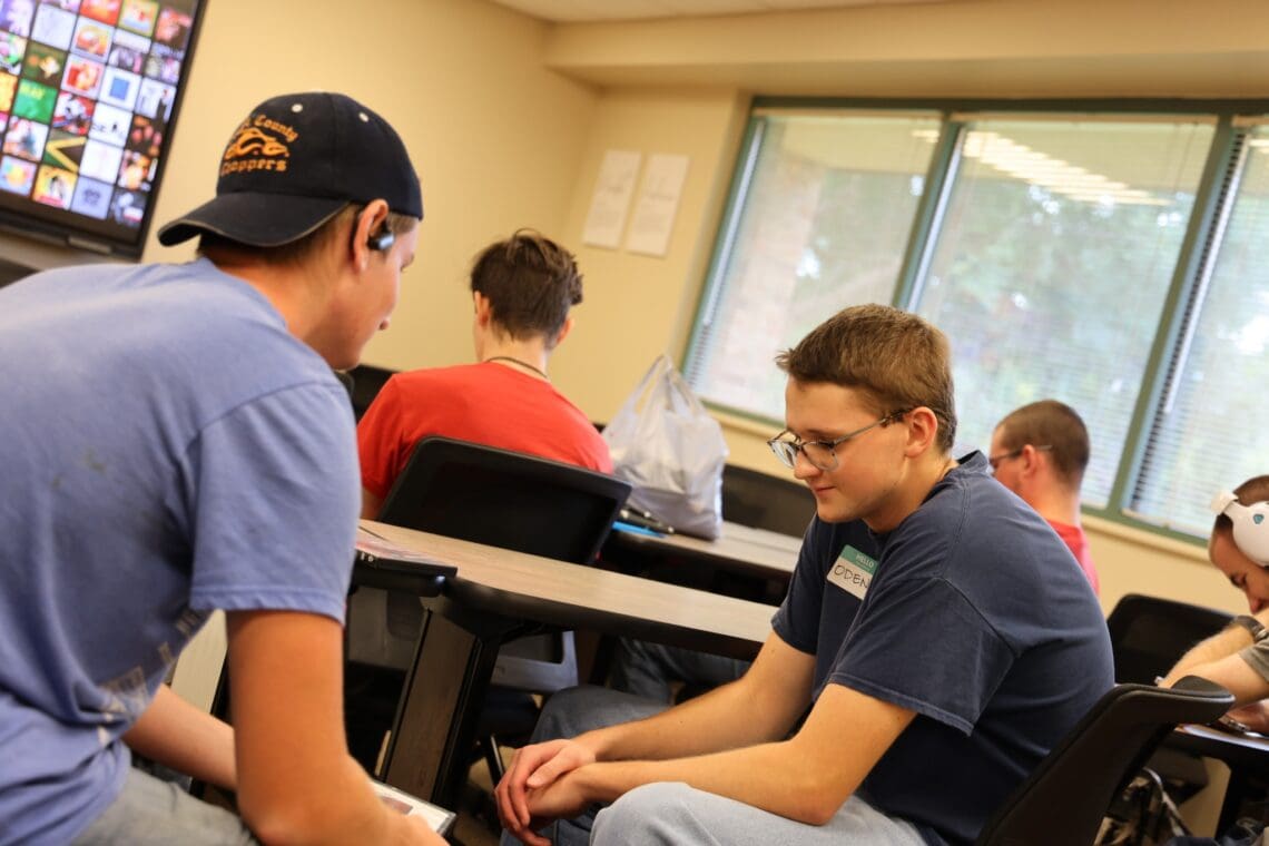 Two Associates sit in the waiting area, chatting and getting to know each other. 