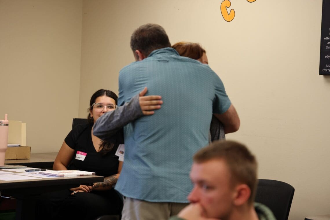 Parent hugs an Associate goodbye. 
