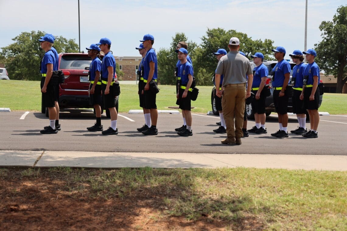 es stand in formation outside in their new uniforms.
