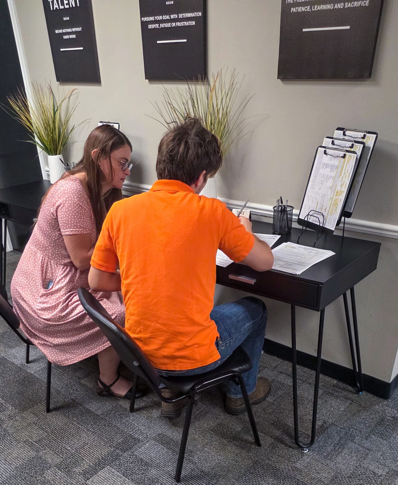 Female coordinator helping male student fill out a job application.