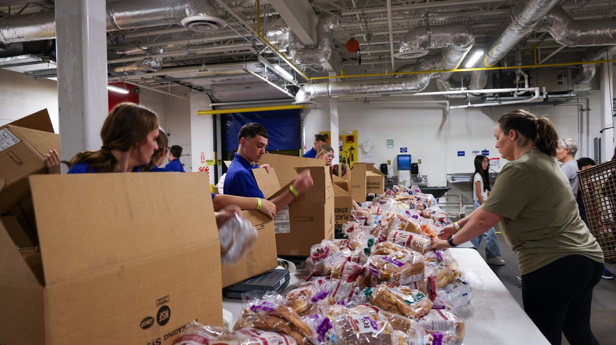 A group of students putting bread into boxes.