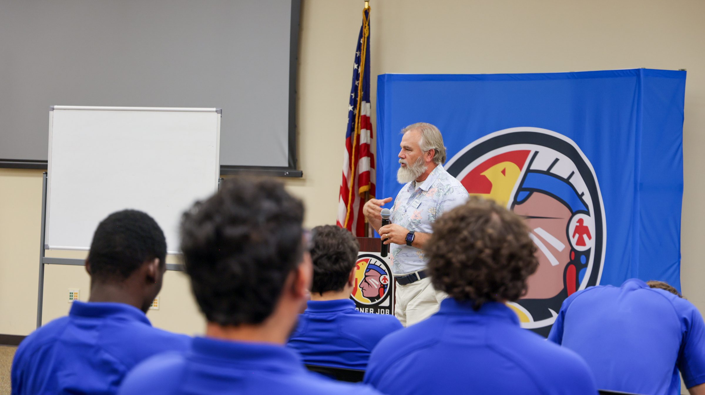 Man speaking to a group of students.