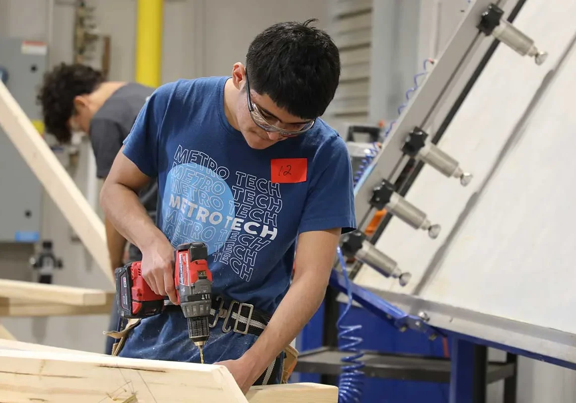 MT-Construction-Trades Student using a drill in carpentry workshop